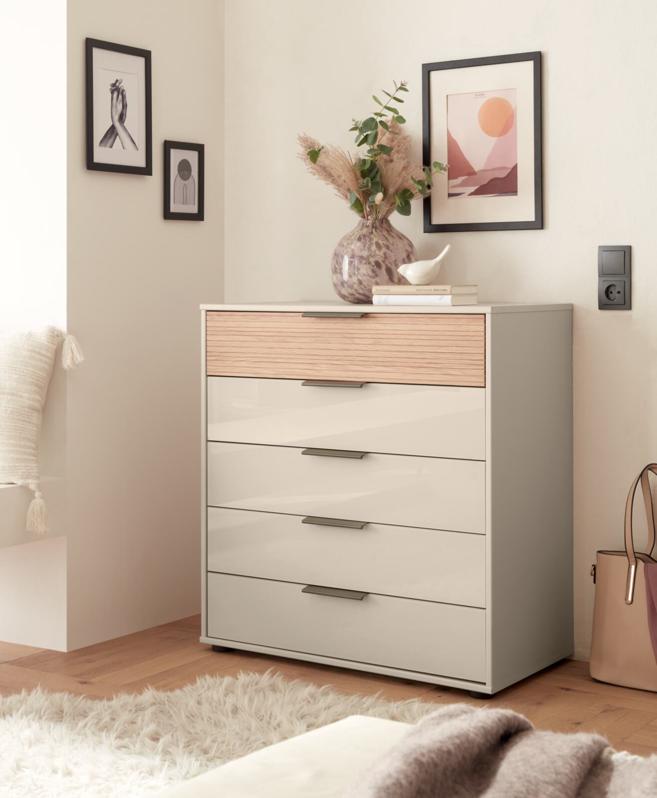 Kommode mit vier Schubladen, Dekoration und Bildern an der Wand.