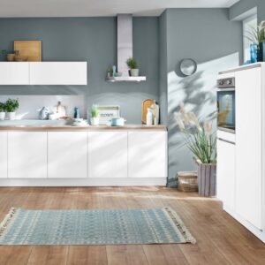 Moderne Küche in Grau und Weiß mit Holzboden und blauem Teppich.