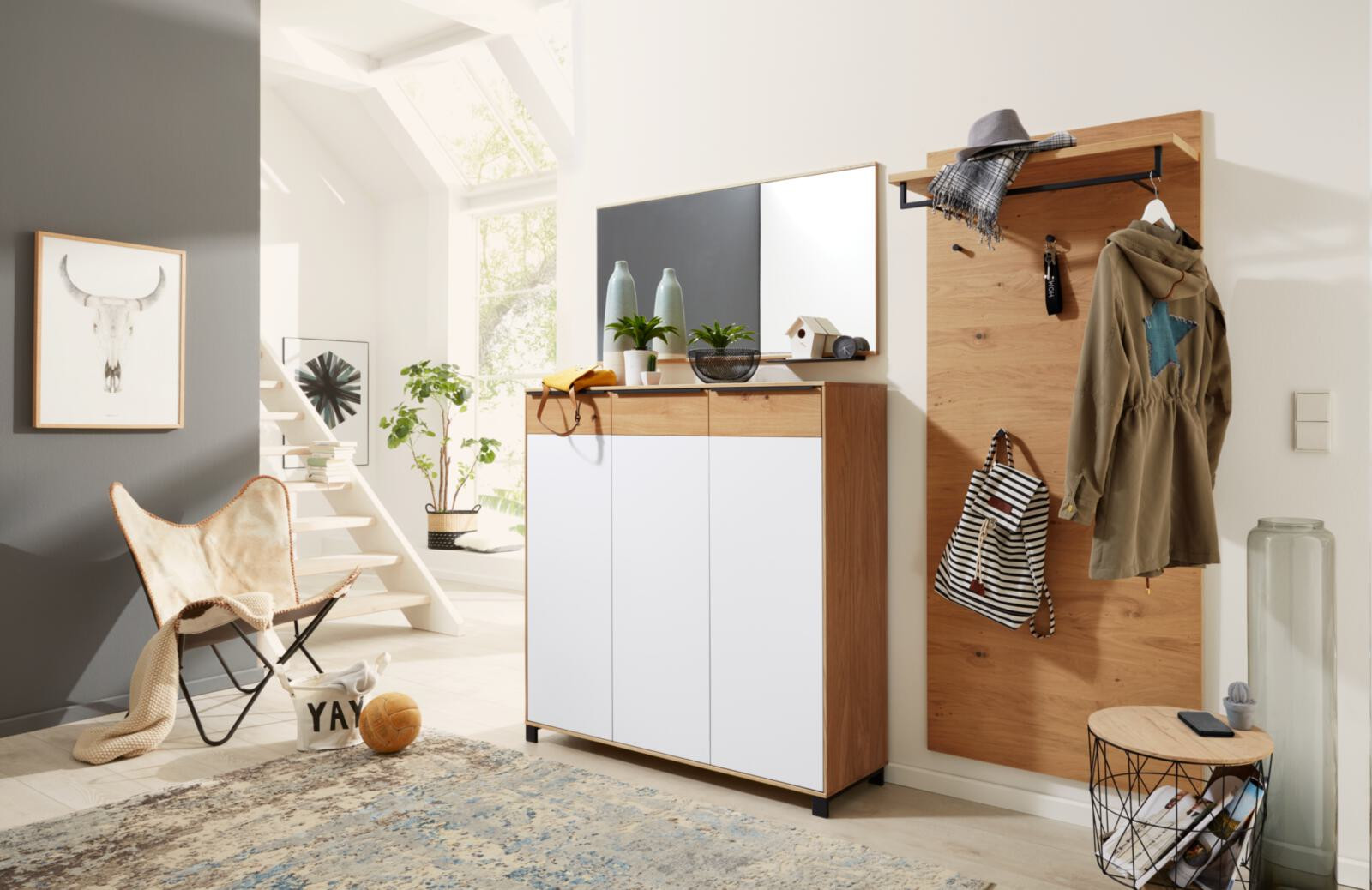 Moderner Eingangsbereich mit Schuhschrank, Spiegel und Holzpaneel mit Jacken.