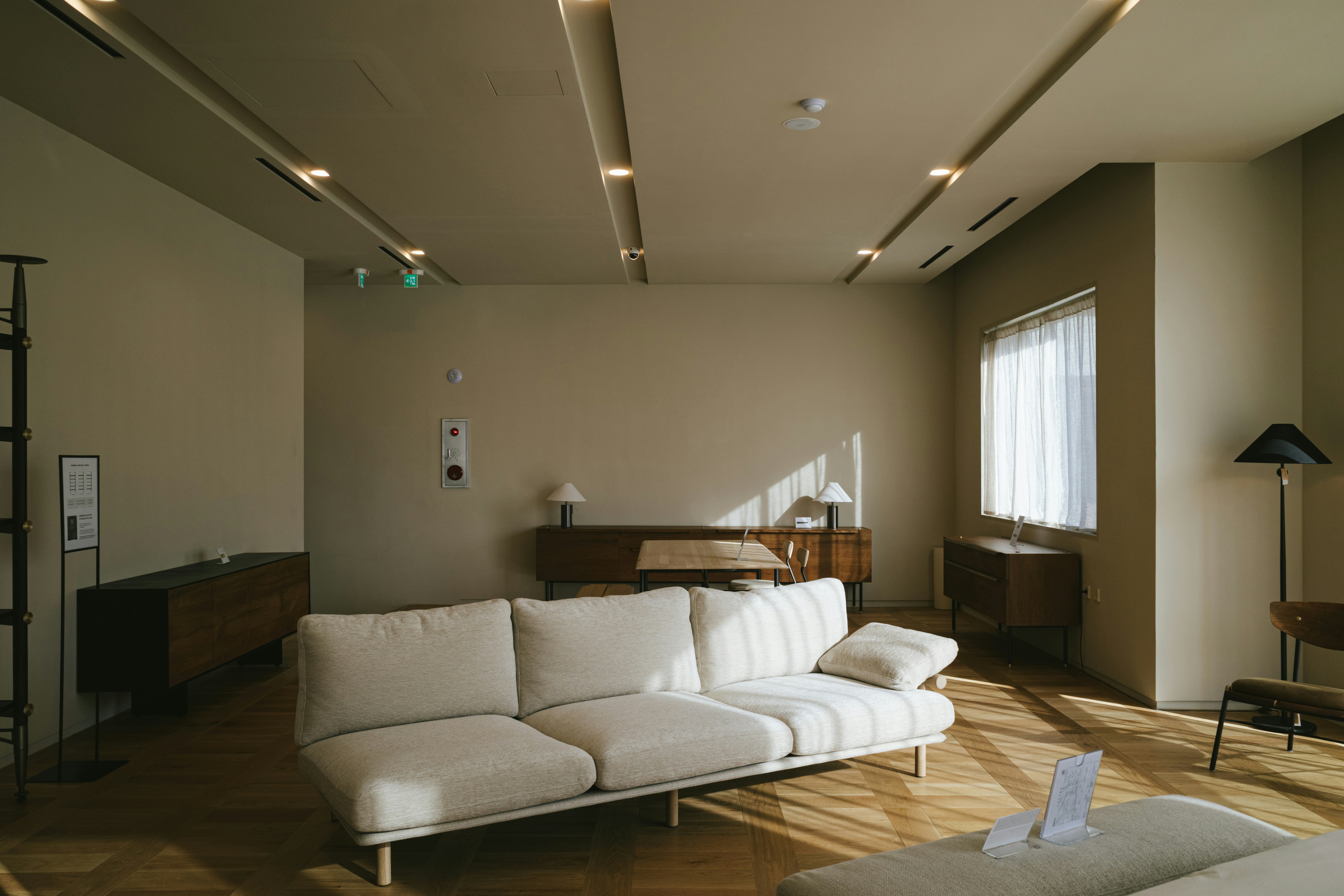 Helles Wohnzimmer mit beigem Sofa, Holzfußboden und Fenster. Neues Zuhause-Update.
