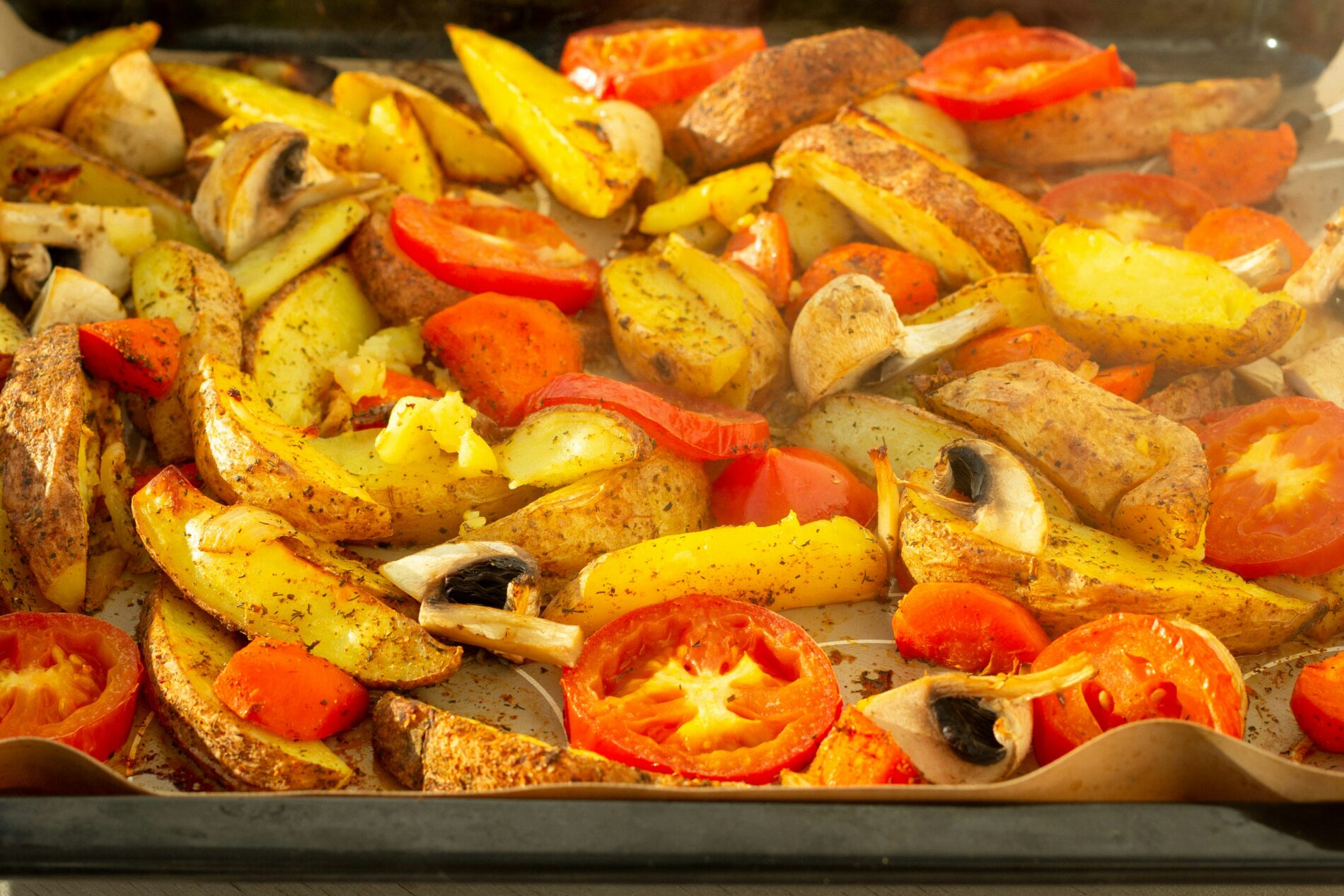 Ofengemüse mit Kartoffeln, Tomaten und Pilzen auf Backpapier. Gesund und lecker!
