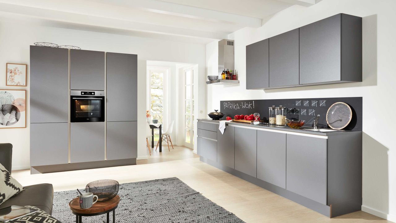 Moderne graue Küche mit eingebautem Backofen und Kücheninsel