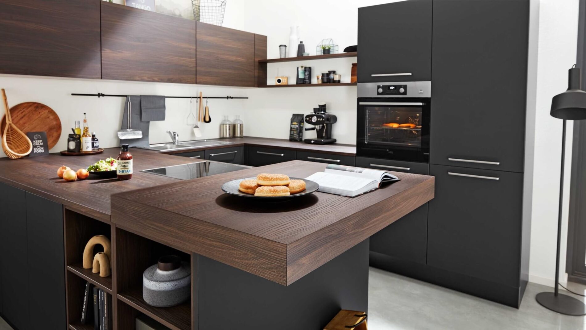 Moderne dunkle Küche mit Holzoberflächen und Frühstück
